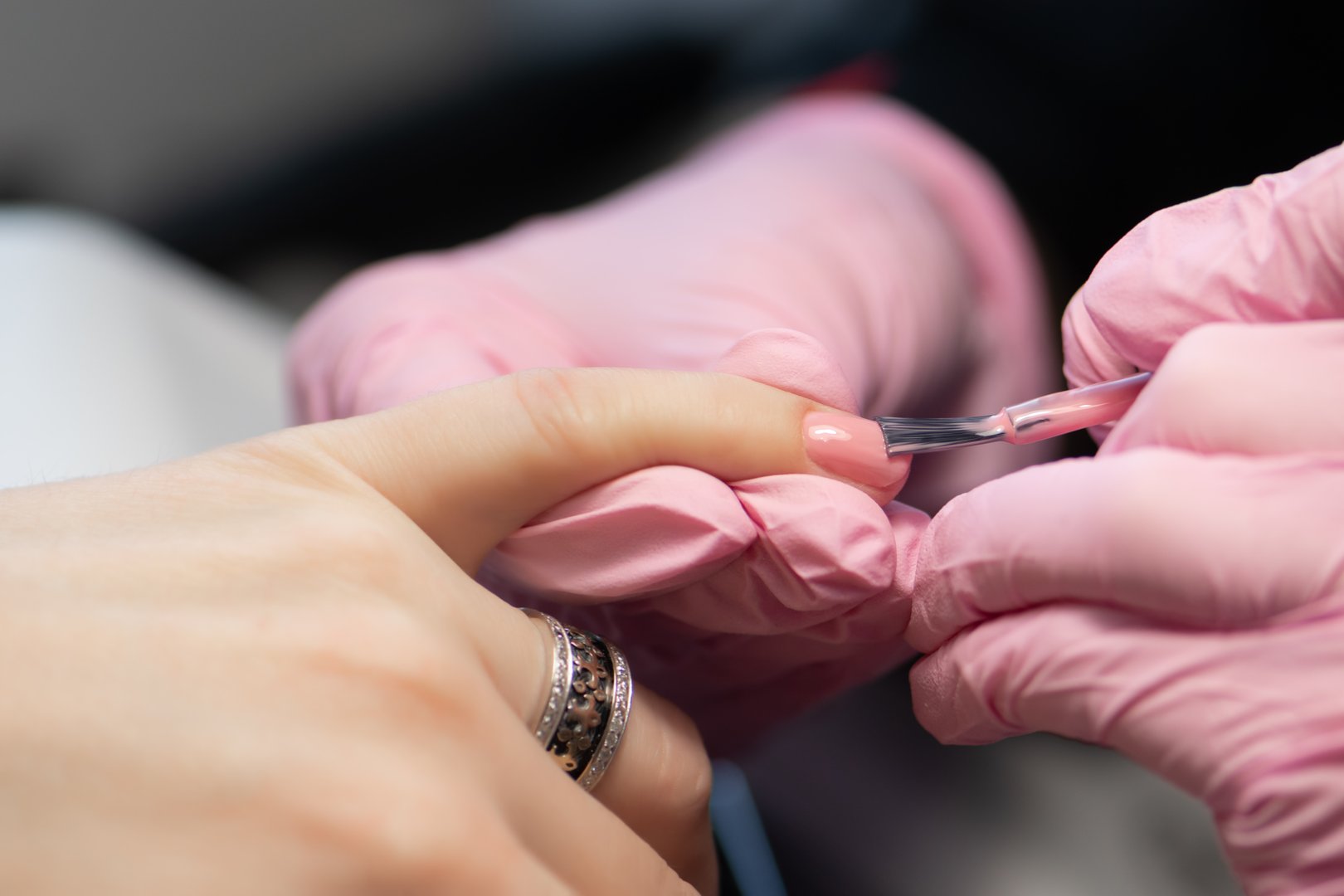 Manicurista haciendo gel diseño de uñas para el cliente de cerca