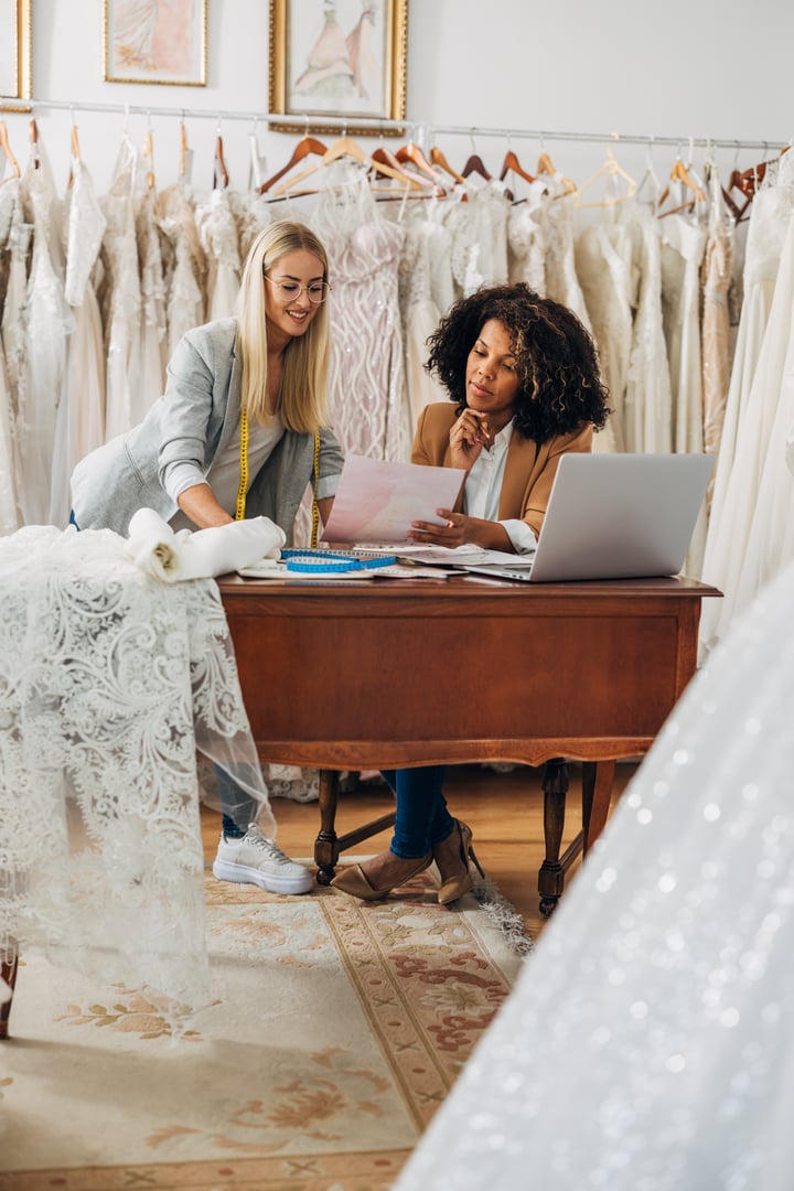 Two women work in a bridal salon as a tailor and a designer