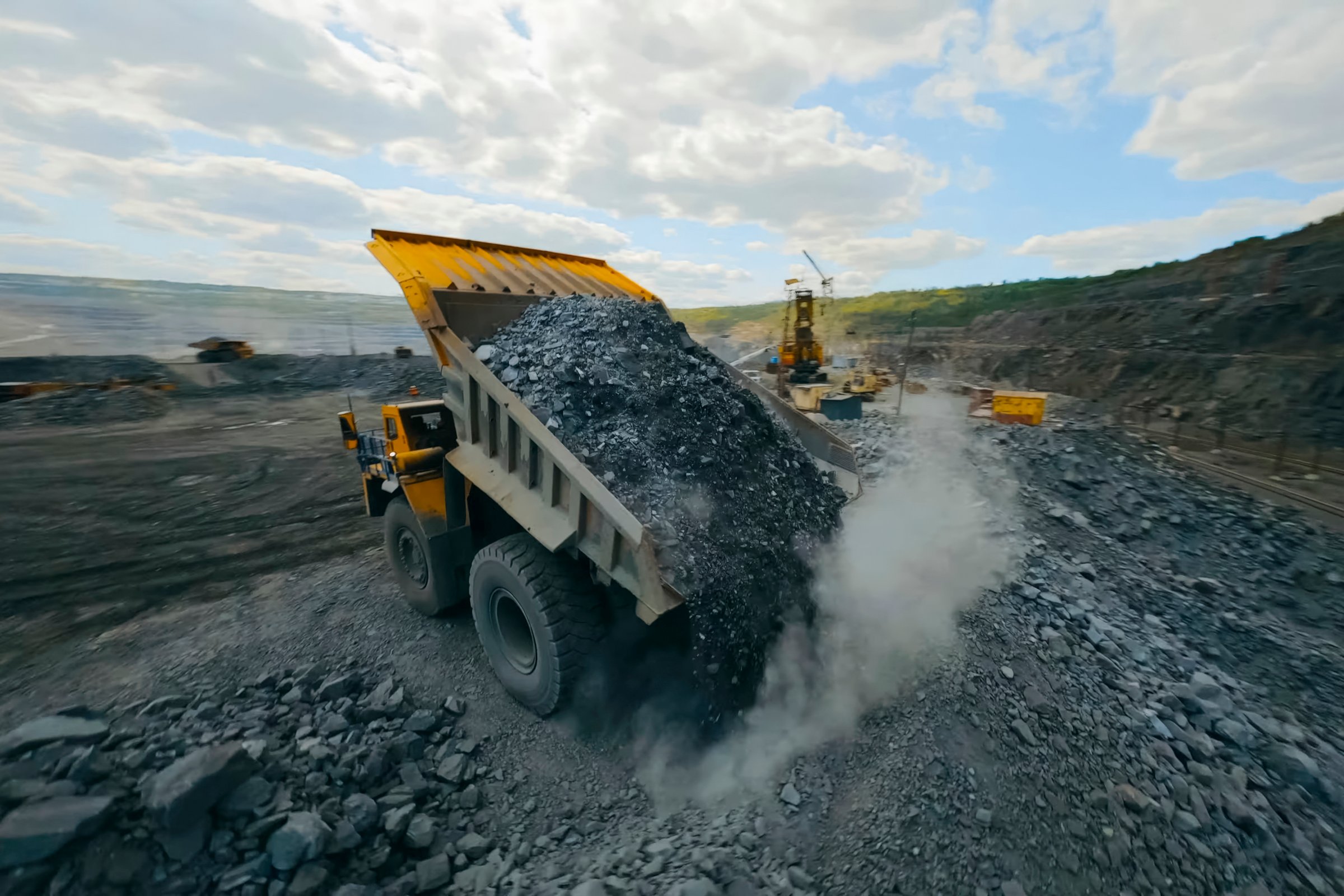 The dump truck dumps crushed stone from the body onto a pile
