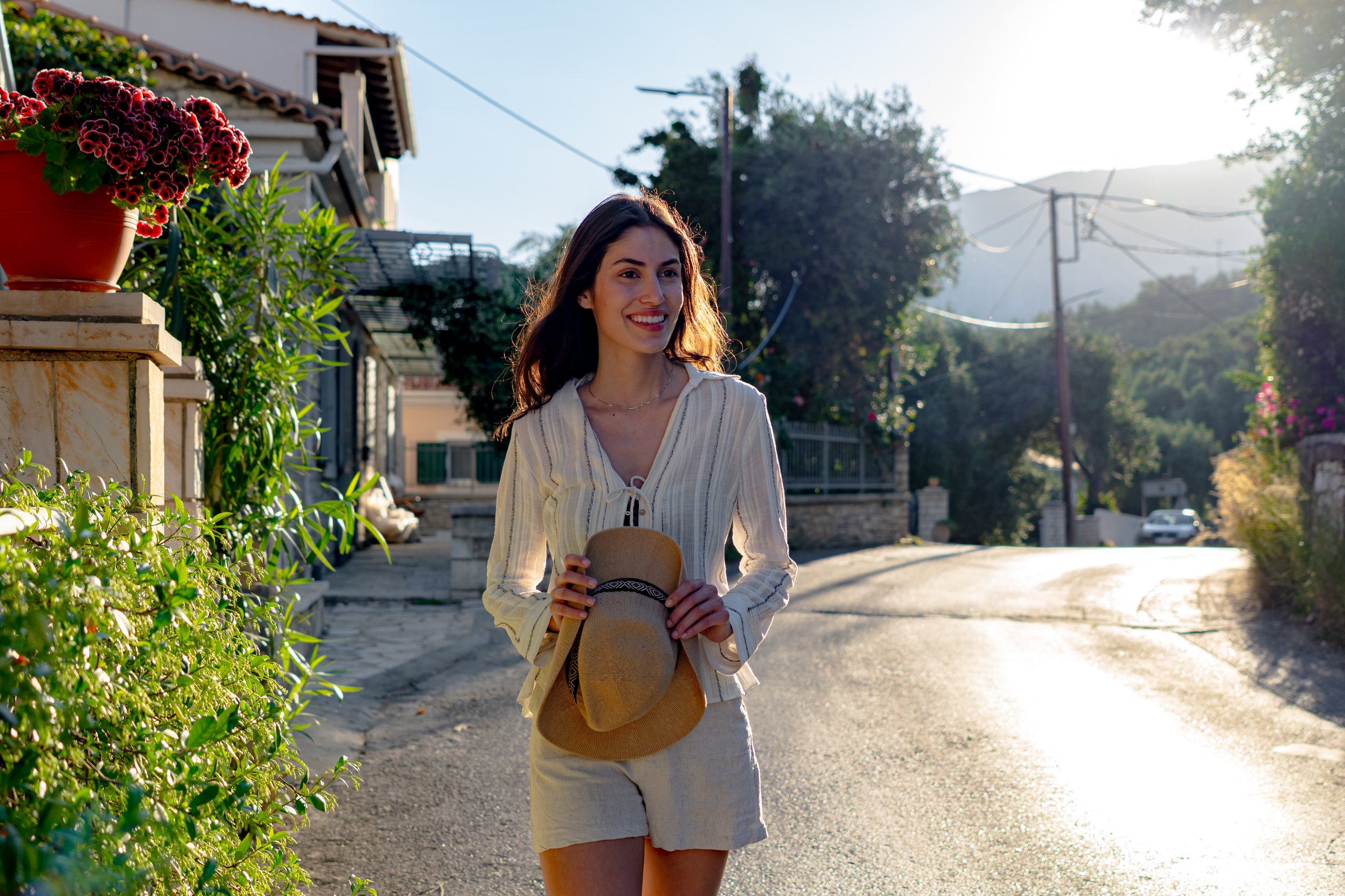 Carefree tourist enjoying a leisurely stroll through a picturesque Greek village on a sunny summer day