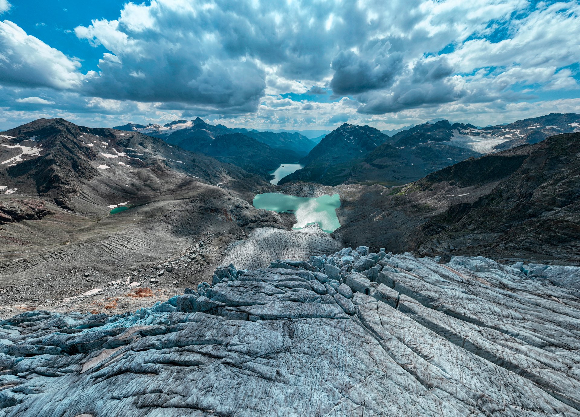 Aerial view of the Fellaria glacier in Valmalenco, Sondrio, Lombardy. Italy. Ice cliff, rock face with waterfalls and lake. Marson glaciological trail. Climate change, melting glaciers, rising temperatures