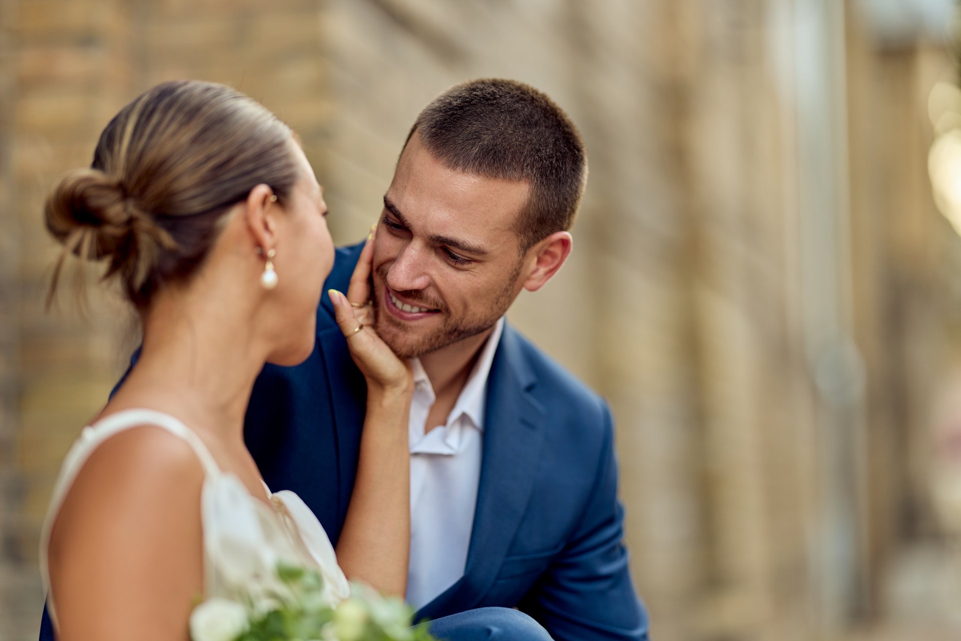 Bride and groom sharing an intimate smile on their wedding day in a romantic setting