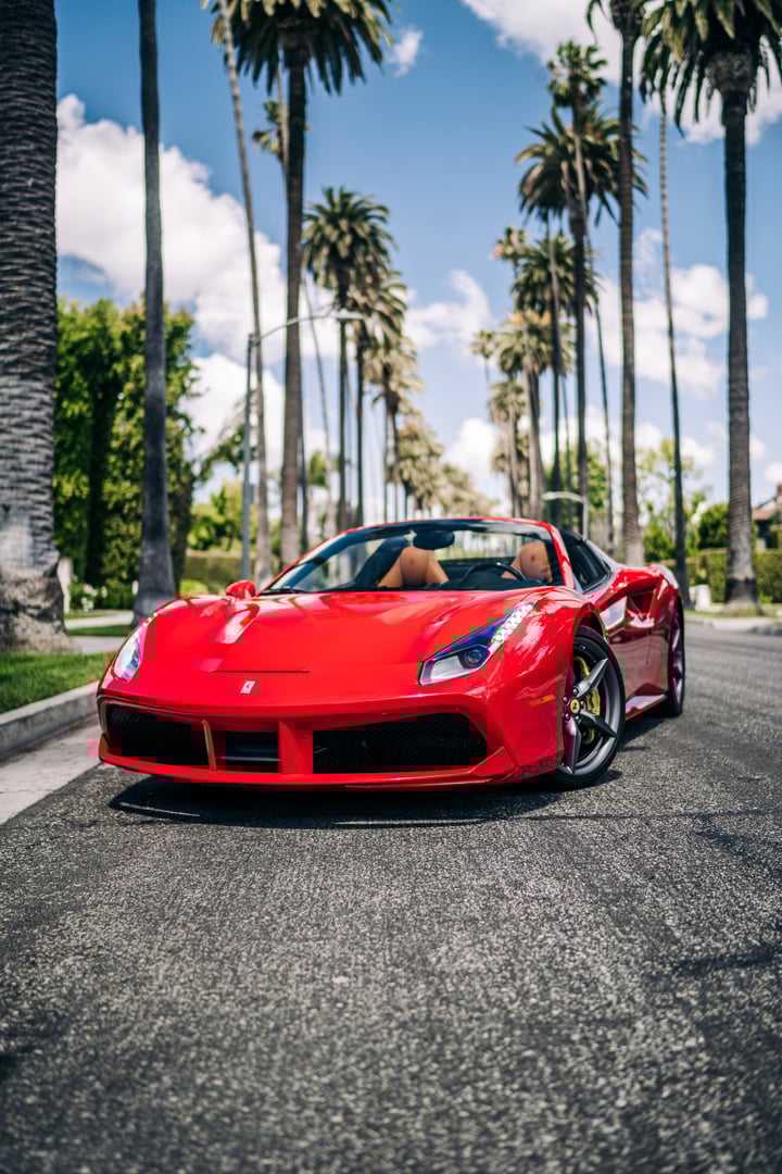 LA, CA, USA July 1, 2025 Ferrari 488 parked showing the front of the car with palm trees in the background