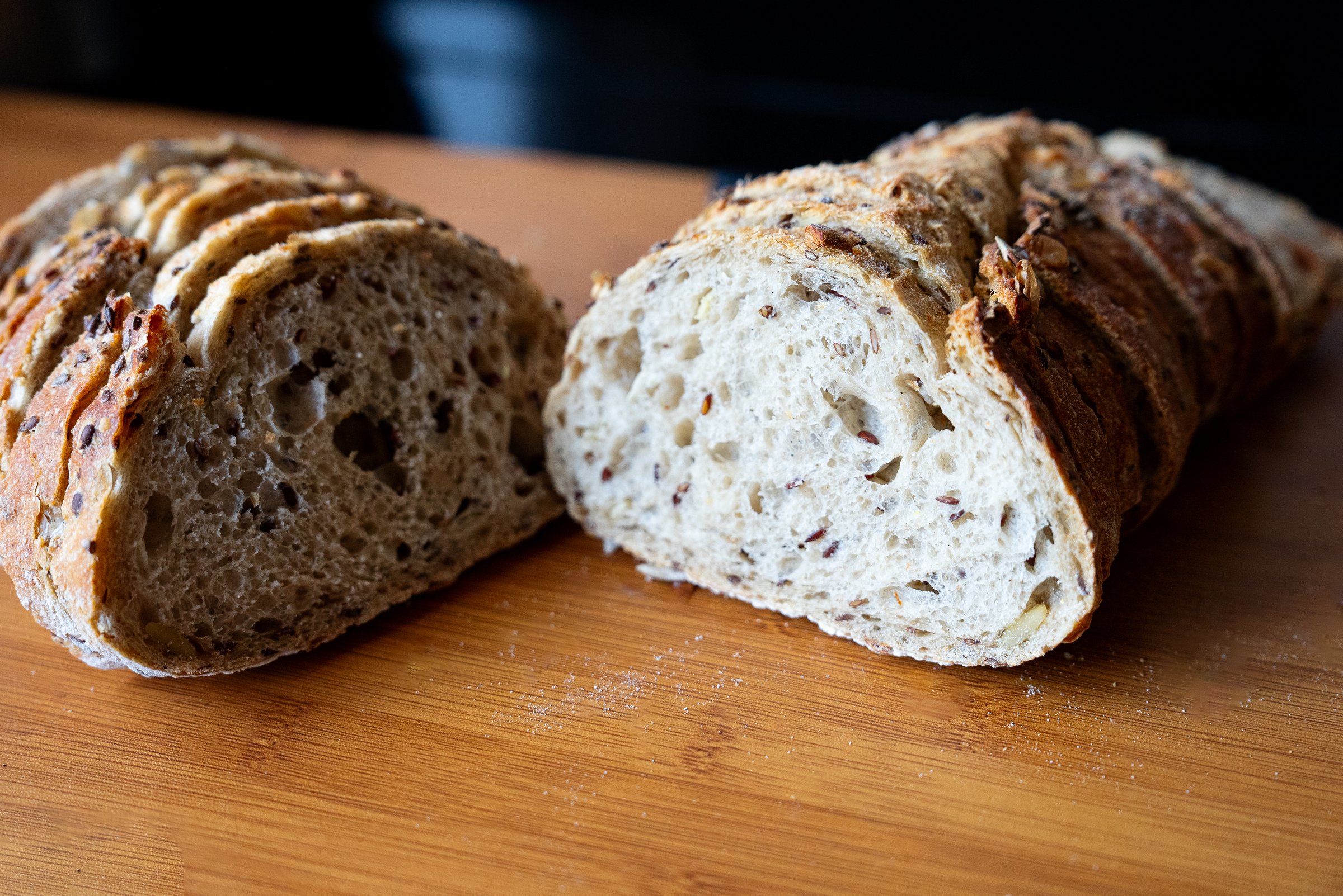 Rustic homemade bread loaf cut in half showing soft crumb texture and crispy crust warm tones