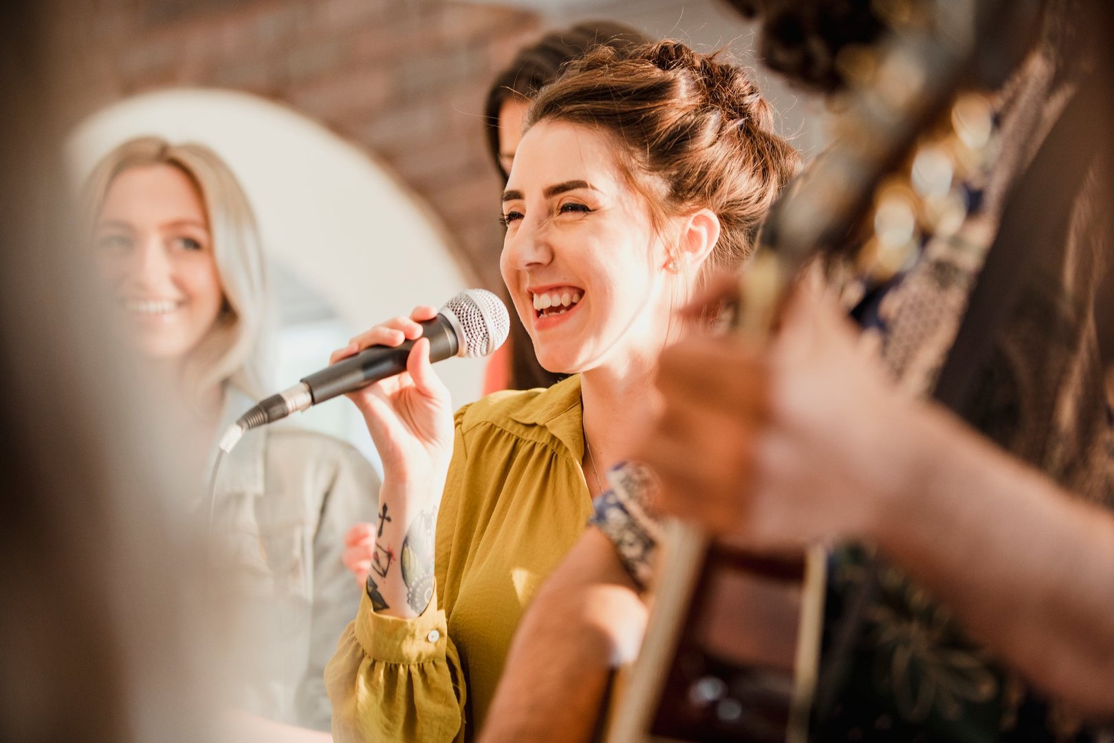 Entertianment at a wedding. A female singer is interacting with the crowd while a man plays an acoustic guitar.
