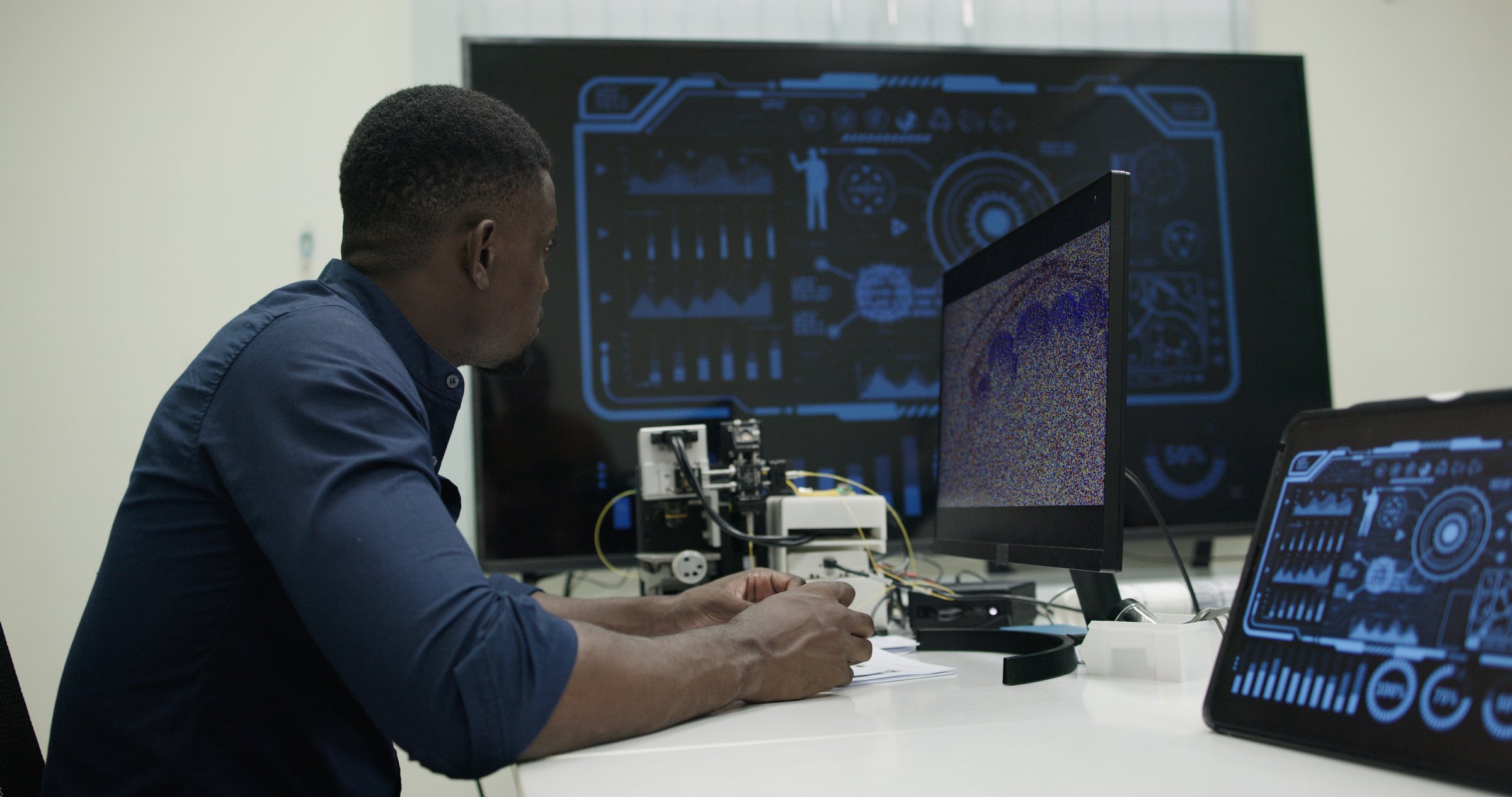 Side view portrait of a black male  software developer using the computer in a high technology office, data systems, and programming and development about engineering in a laboratory