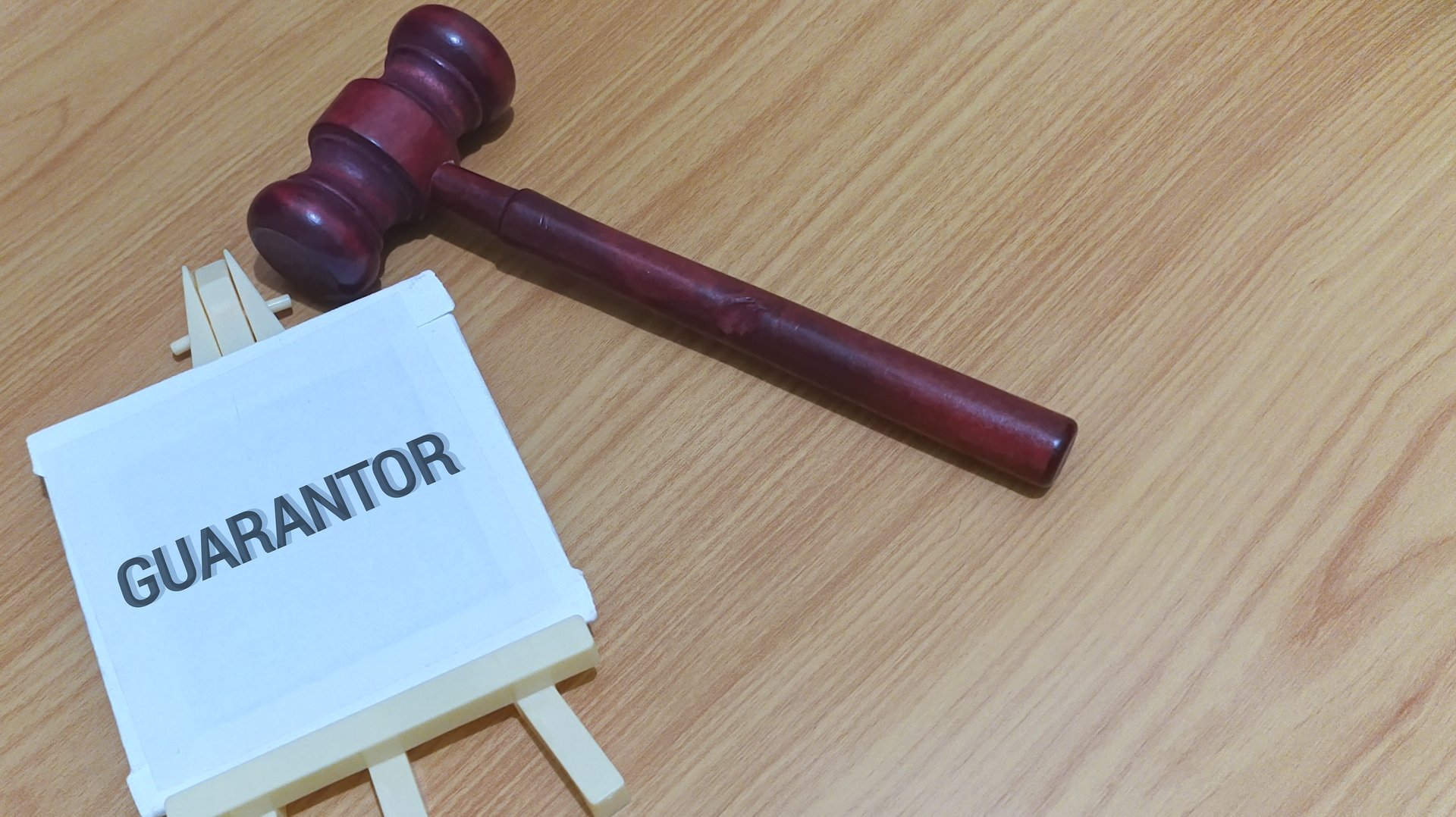 Symbolic gavel and 'Guarantor' sign convey legal authority, trust, and financial assurance. Essential for business, finance, and legal concepts.