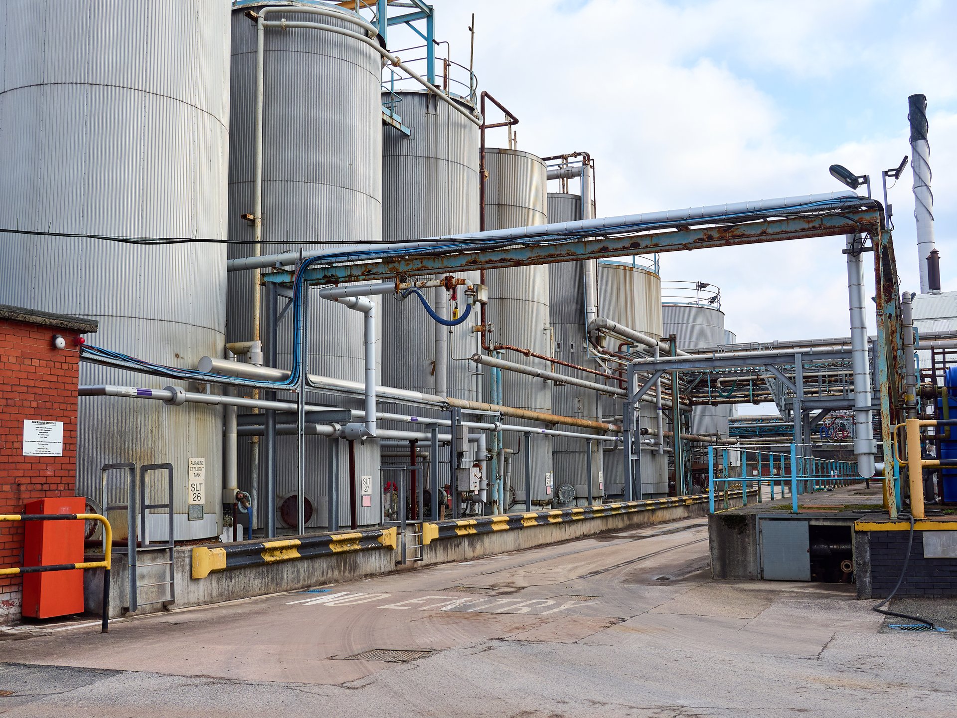 Industrial chemical plant with large storage tanks and intricate piping system.