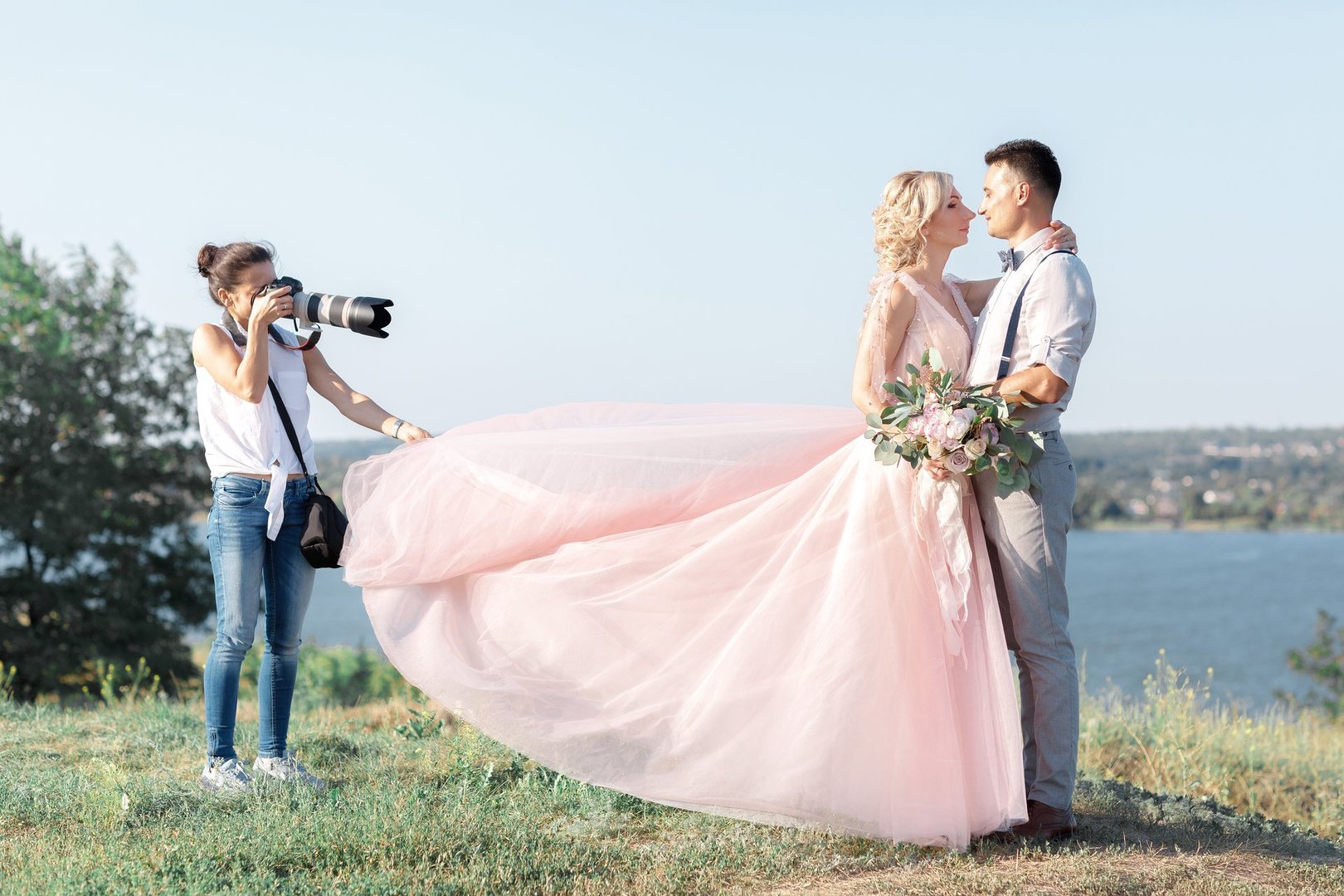 wedding photographer takes pictures of bride and groom in nature. wedding couple on photo shoot. photographer in action