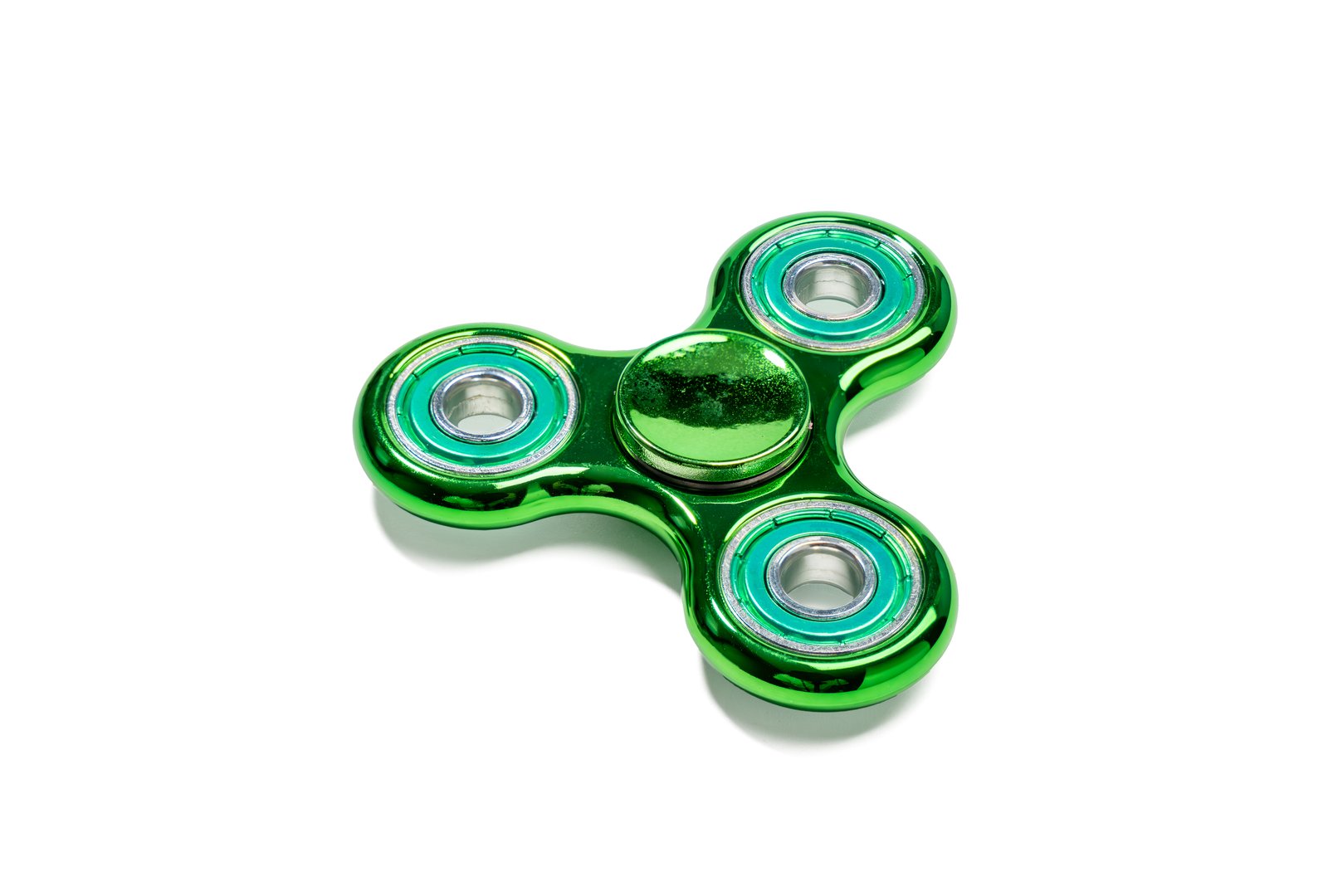 Green metallic fidget spinner. Shiny green fidget spinner with three arms and metal bearings. Designed for stress relief and improving focus.