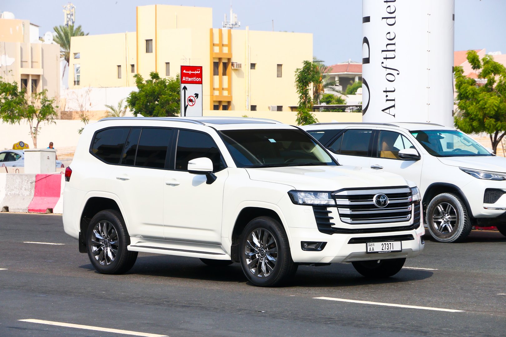 Dubai, UAE - July 3, 2024: White luxury offroad car Toyota Land Cruiser 300 in the city street.