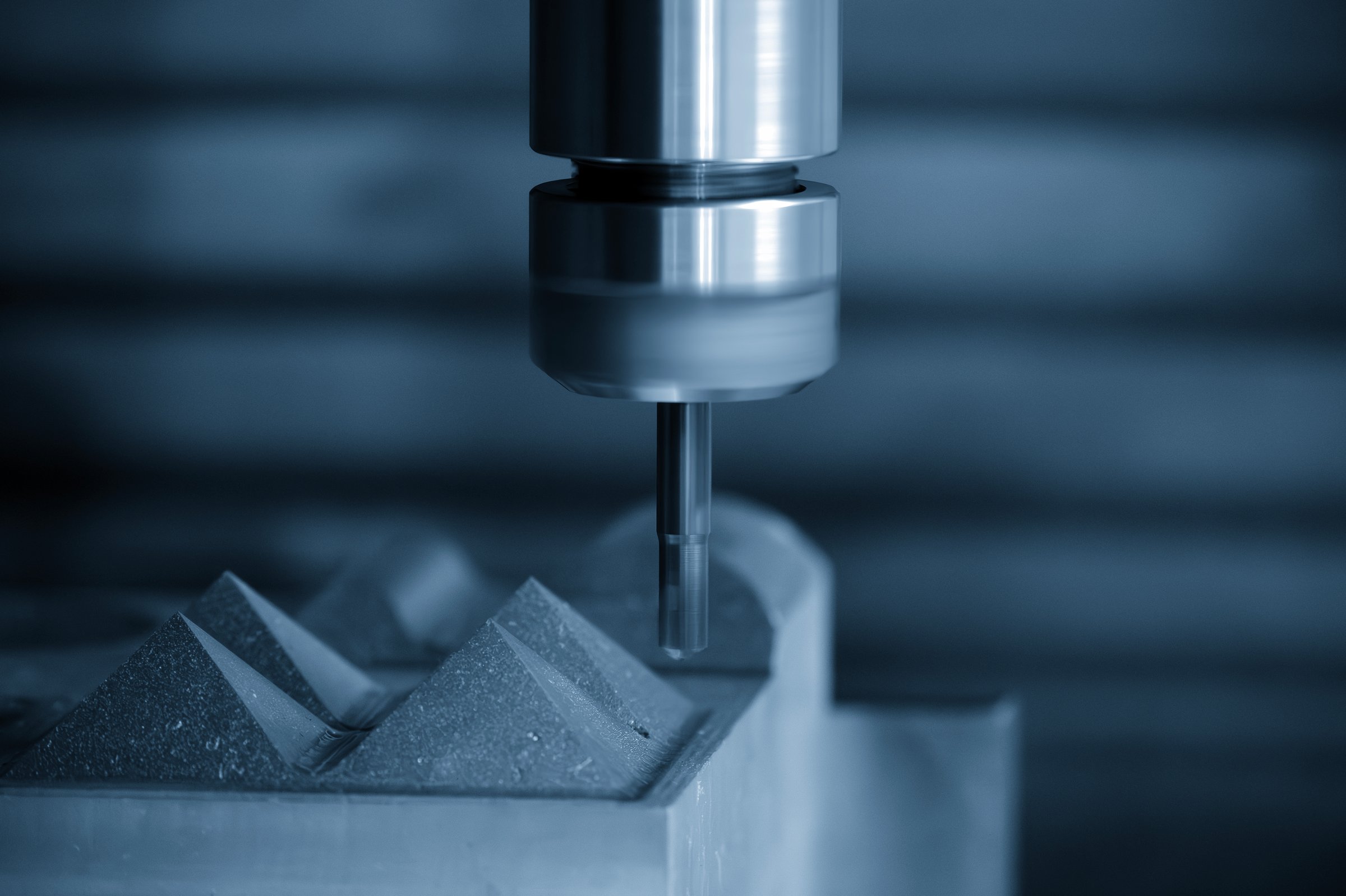 The CNC milling machine rough cutting the mold parts by indexable tools in the blue tone. The mold and die manufacturing process by machining center with the indexable tools.