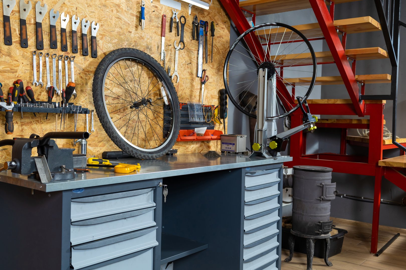 Wall organizer with wrenches, screwdrivers and pliers, bicycle wheel mounted on truing stand