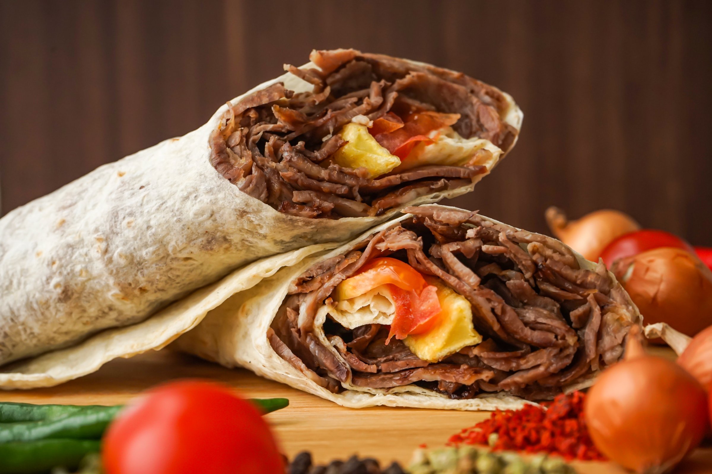 Beef Doner Wraps Shawarma isolated on wooden table closeup side view of arabic and turkish street food