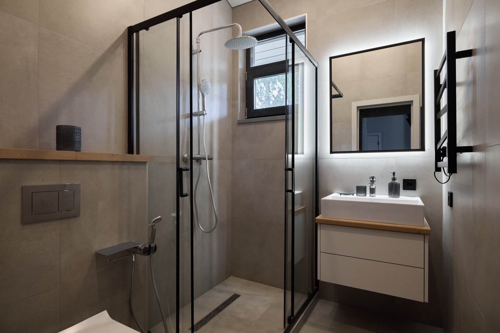 The stylish minimalist bathroom showcases a sleek glass shower alongside modern, highquality fixtures