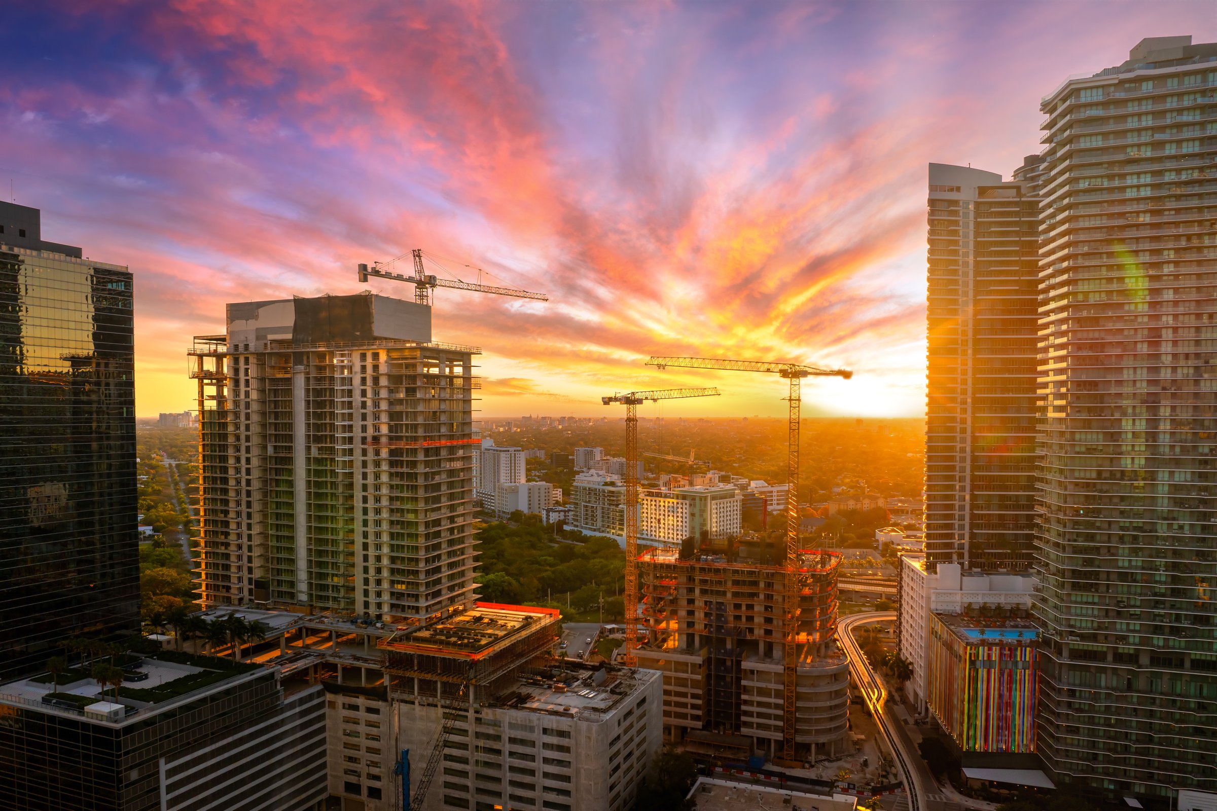 Miami, Florida. Developing American megapolis with new high-rise buildings under construction at sunset.