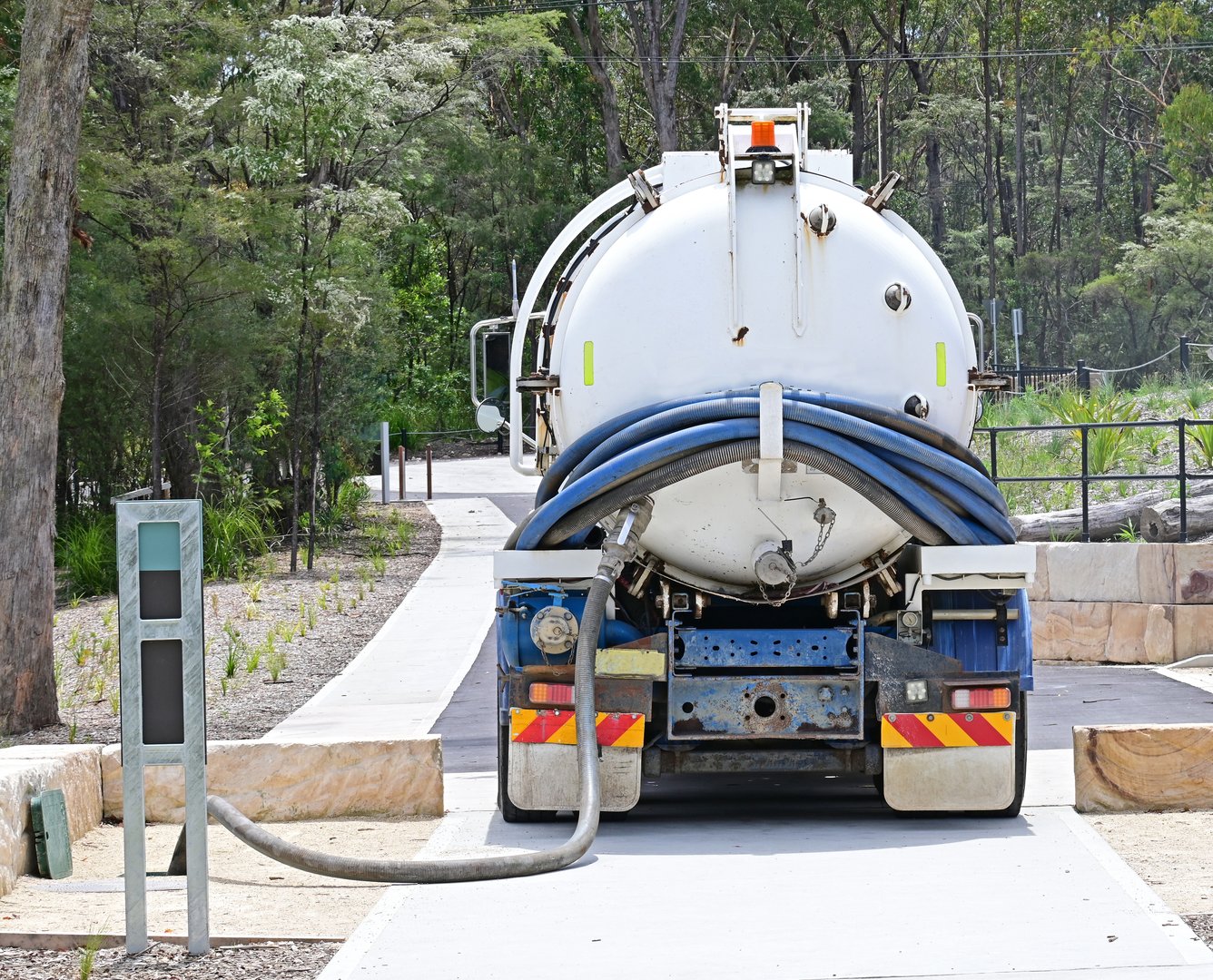 Tanker truck pumping out sewage from an underground tank