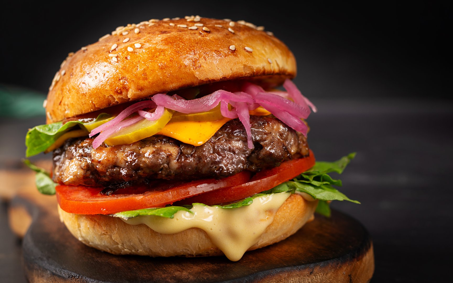 Beef hamburger. Sandwich with beef burger, tomatoes, cheese, pickled cucumber and lettuce. Cheeseburger.