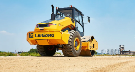 Yellow LiuGong construction vehicle on dirt, front view, clear sky, industrial background.