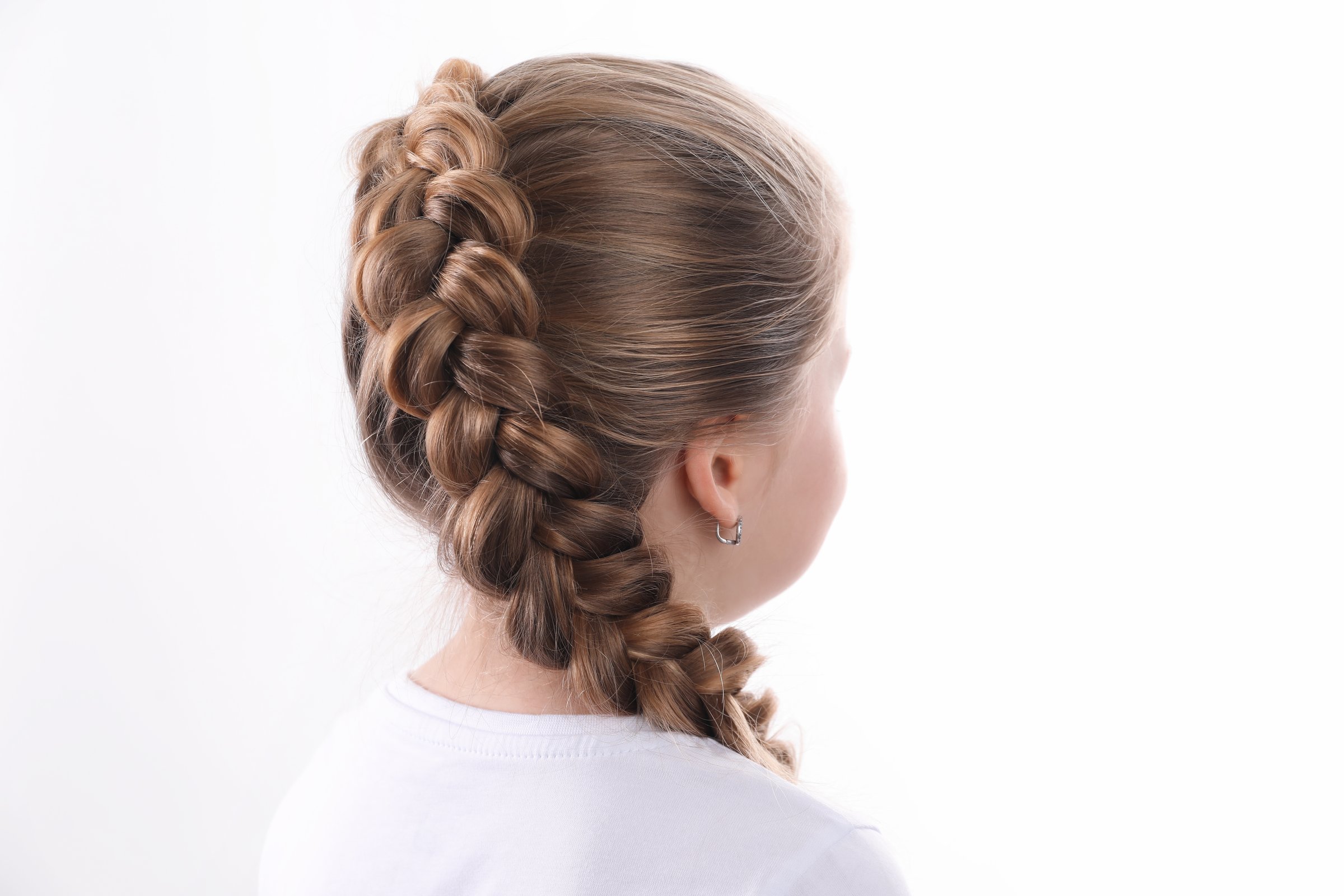 Little girl with braided hair on white background, back view