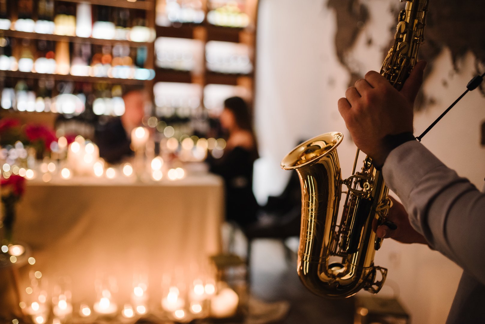 Saxophonist's hands while playing jazz. Musician hold sax at romantic date on Valentine's Day in restaurant. Jazz music concept closeup.