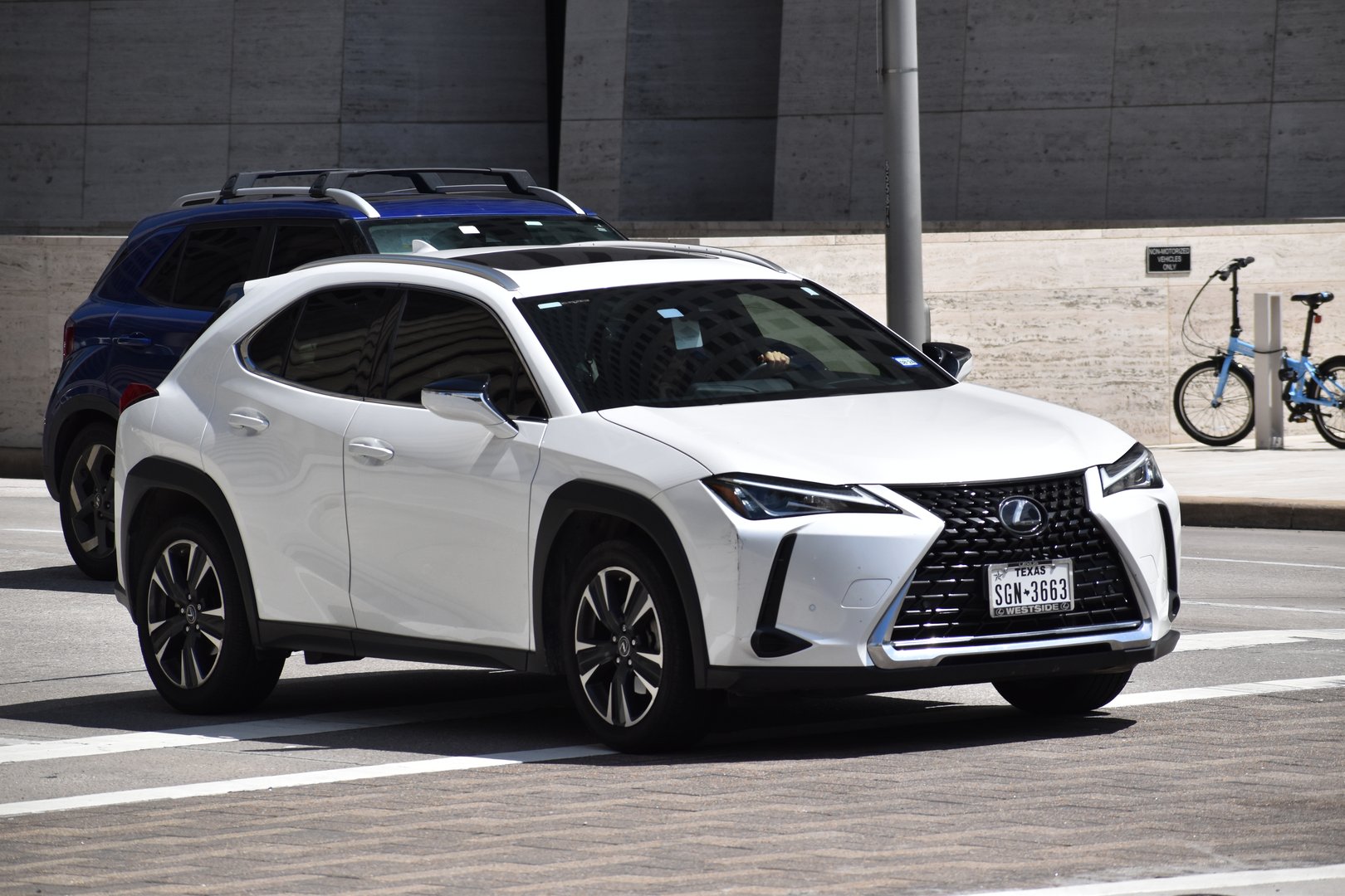 Houston, TX USA - May 15, 2024 - A portrait of a white Lexus SUV cruising in a downtown district
