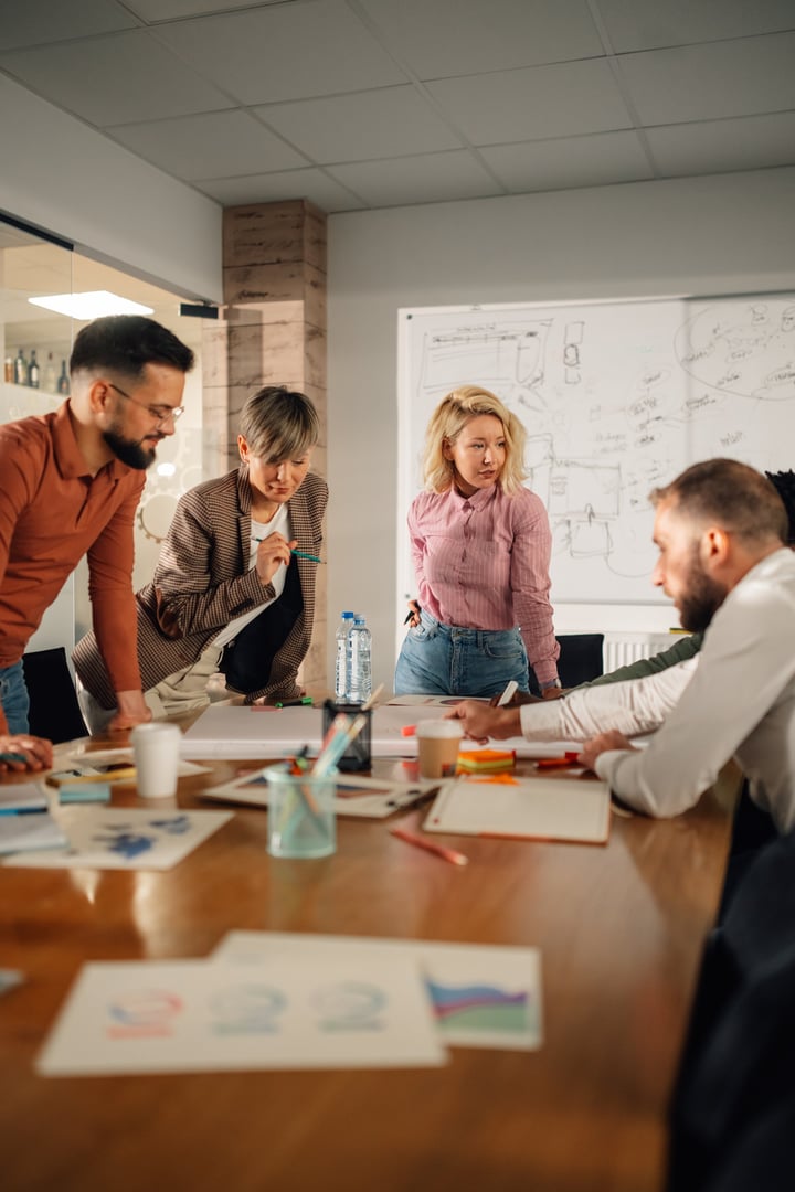 Marketing professionals working together on a new project, analyzing data and brainstorming ideas in a modern office environment, demonstrating teamwork and collaboration
