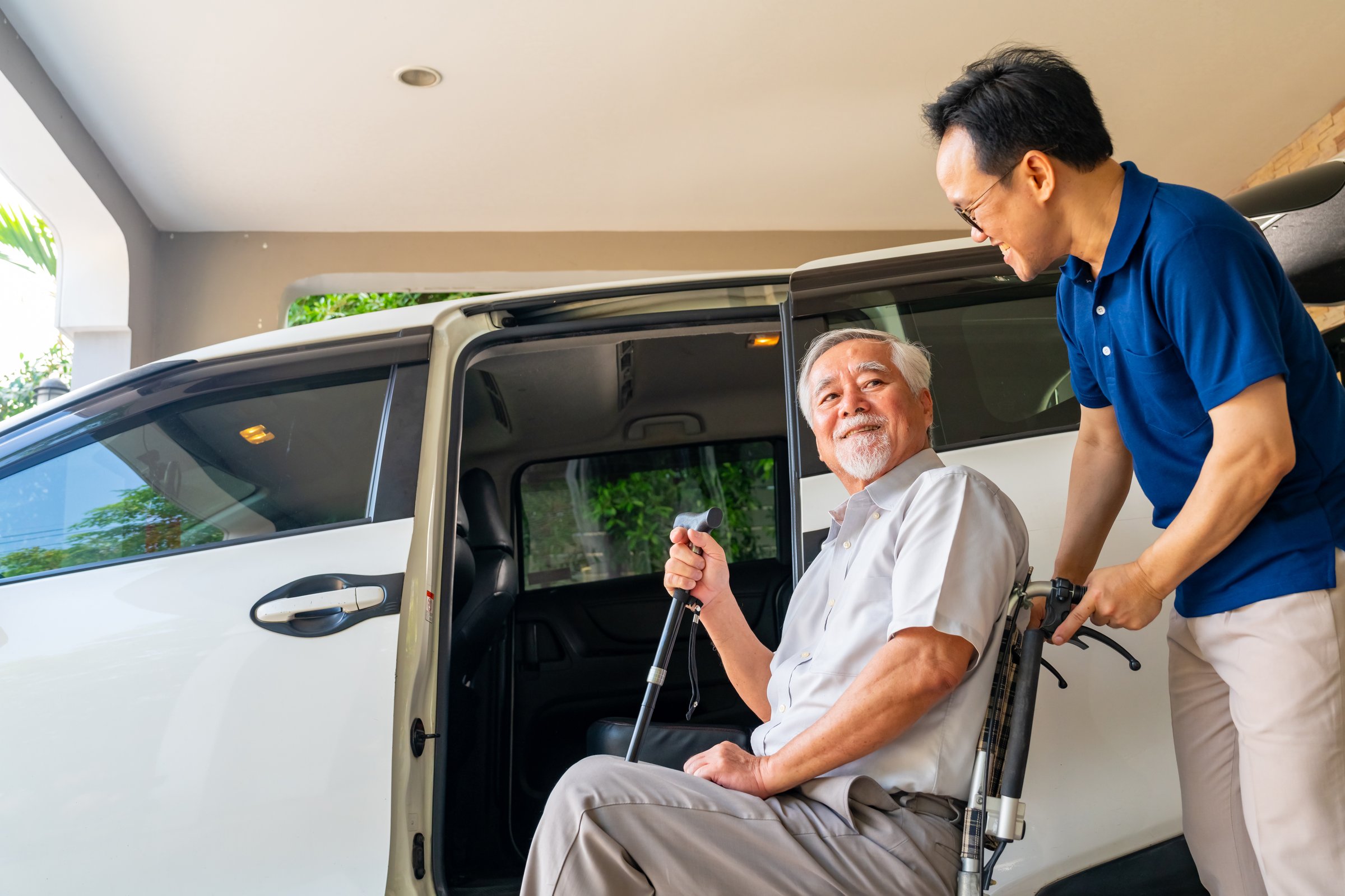 Asian man caregiver or taxi driver helping senior man patient get in the car to get to medical appointments or healthcare therapy sessions at hospital. Assisted elderly patient transportation services