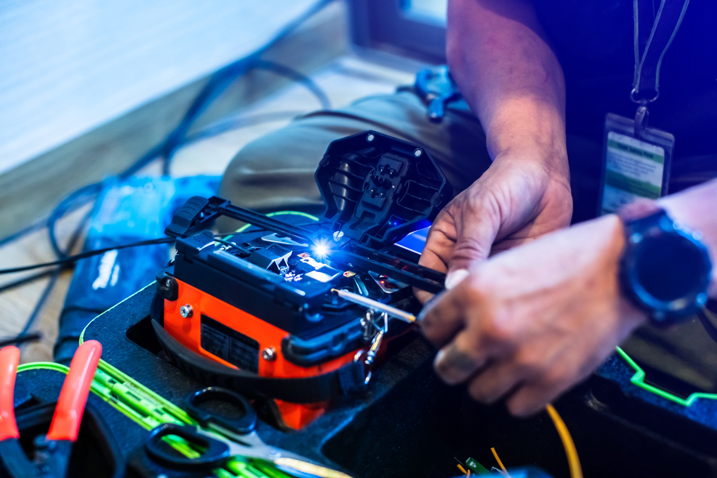 Selective focus to fiber optic splicing cable tools. Fixing Internet Cable. Technician is welding fiber optic cable at the job site. installation or repair cable.