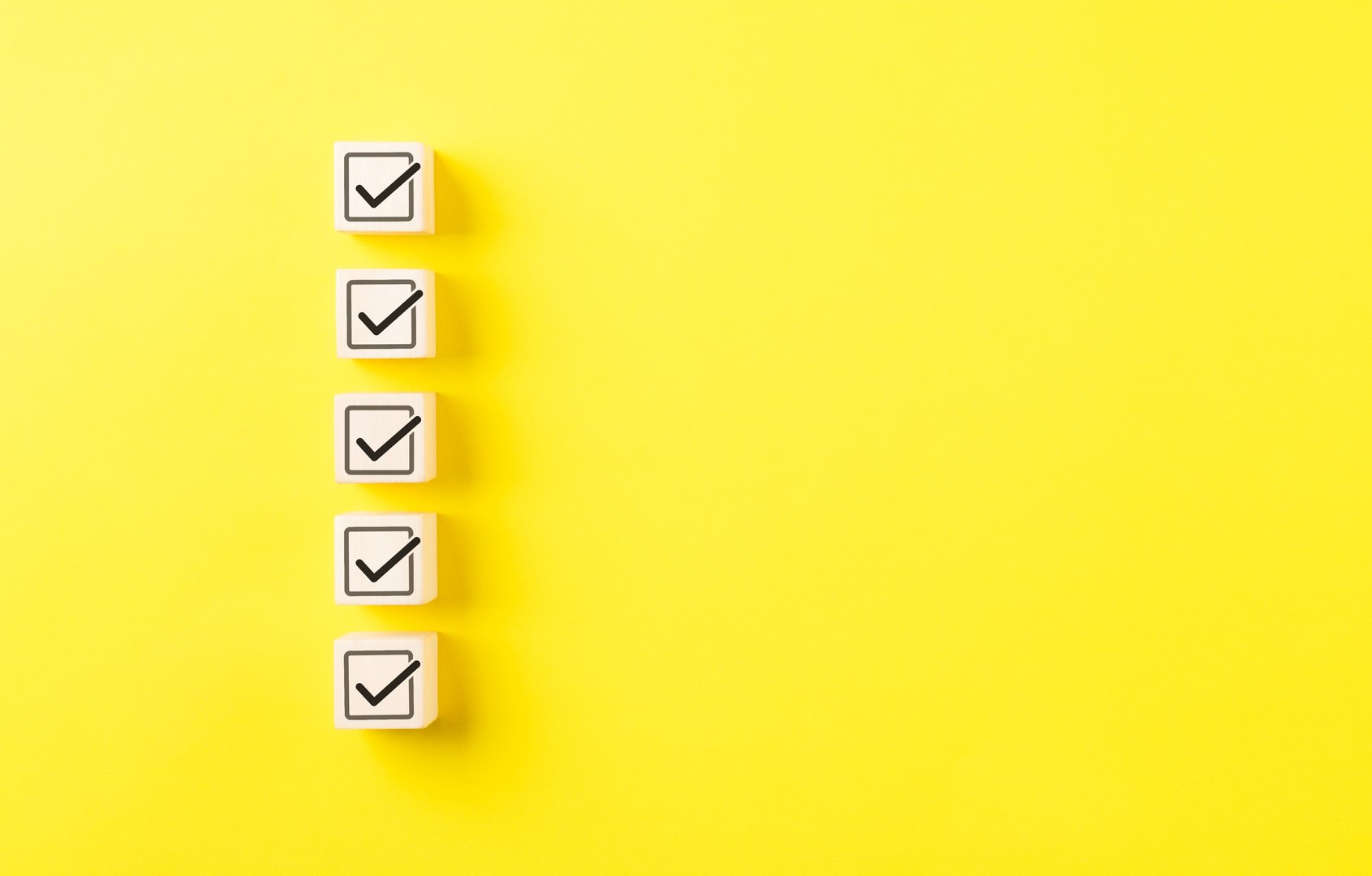 Checklist concept. Correct sign tick check mark on wooden block with copy space for the checklist on yellow background. Business survey questionnaire, Exam test process, filling digital form online,