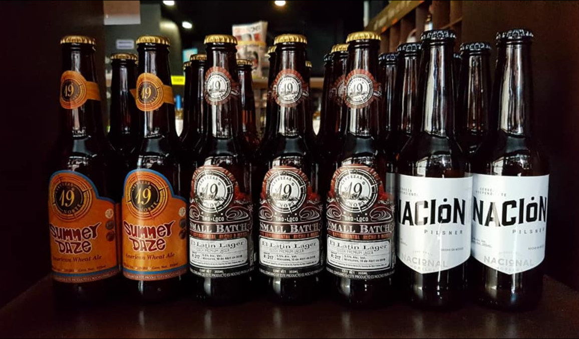 Bottles of Summer Daze, Small Batch, and Nación beer displayed on shelves.