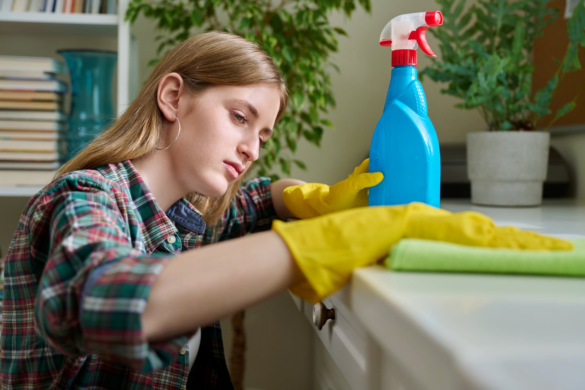 Young woman cleaning room, dusting with spray and cloth. Cleanliness, housekeeping, routine, special organic cleaning products concept
