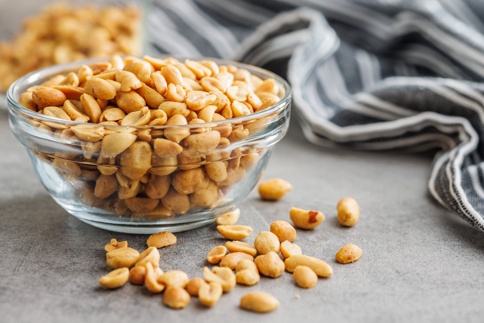 Salted roasted peanuts in bowl on a kitchen table