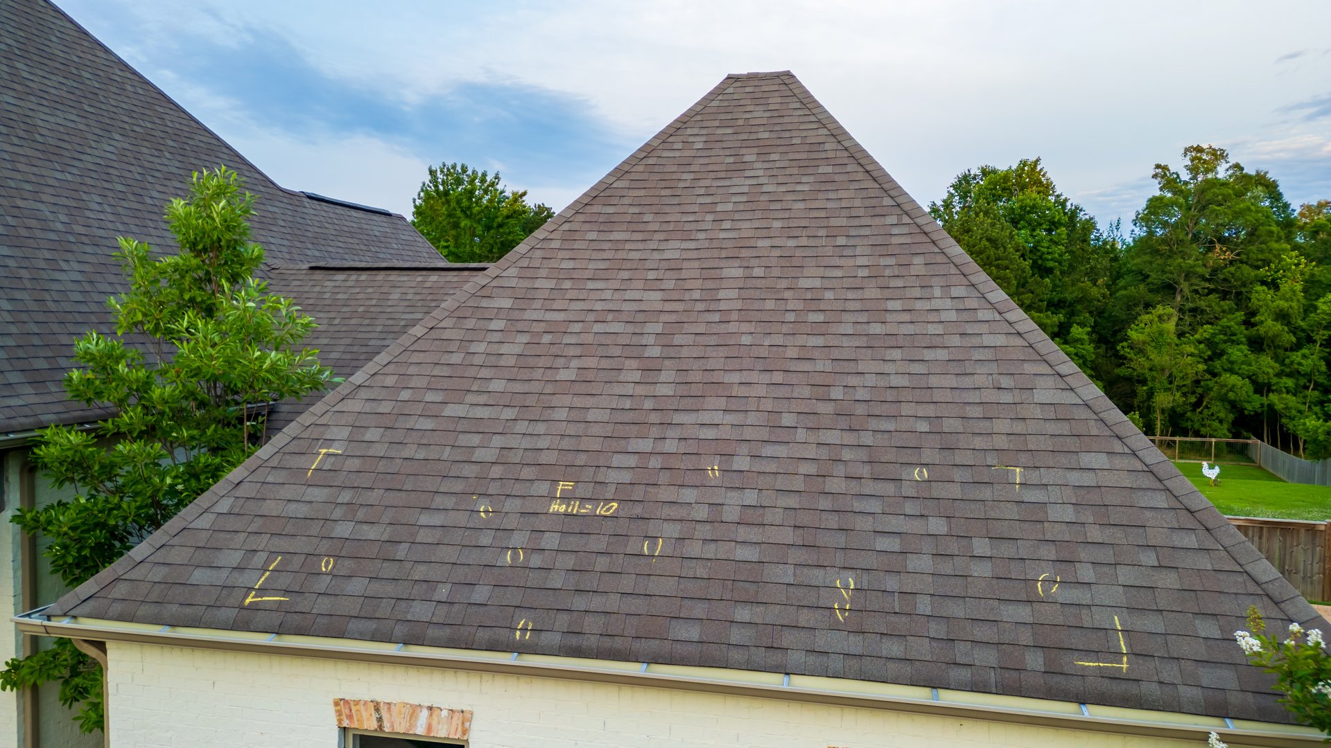 Roof with hail damage and marking from hail insurance inspection