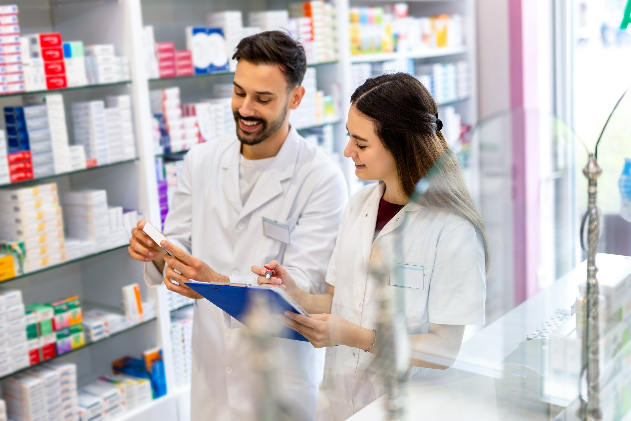 Shot of two pharmacists working together in a drugstore. They are doing a list of medications at the pharmacy.