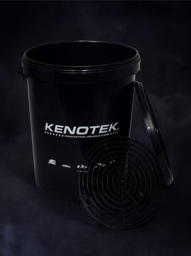 Man wiping car wheel with grey microfiber rag outdoors, closeup