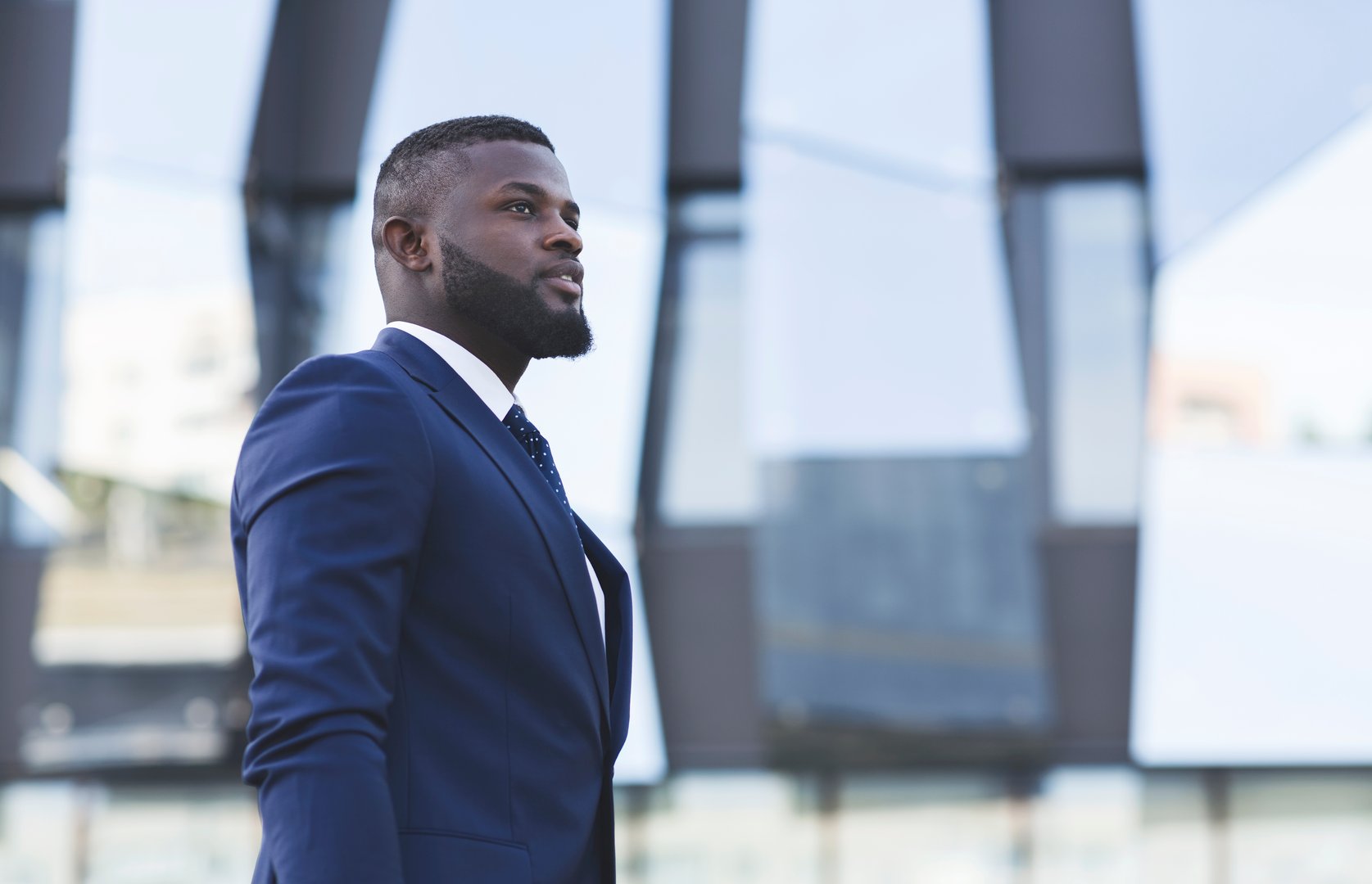 Young Black Businessman Looking Aside Standing In Urban Area. Starting Business Career. Free Space For Text