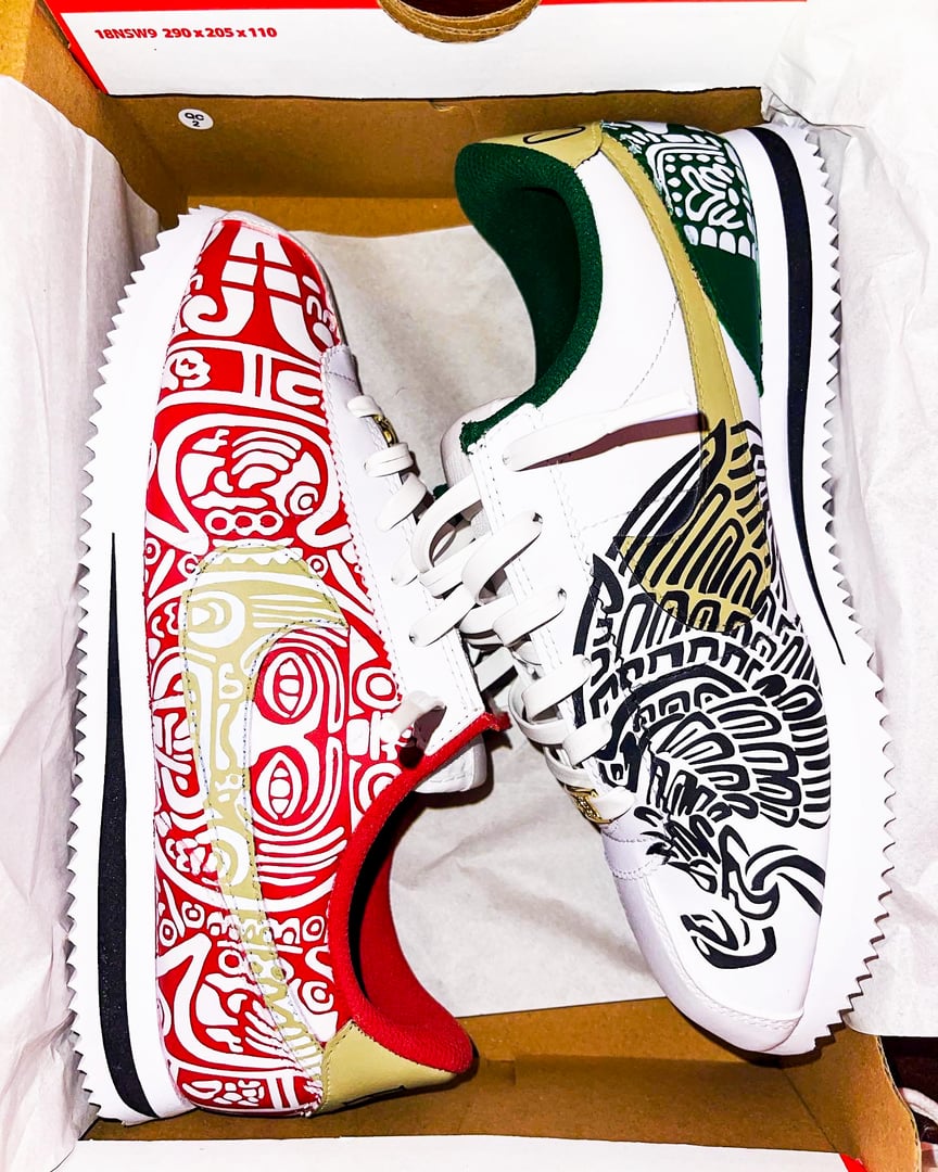 Unique sneakers with tribal patterns: one shoe is red and white, the other black and white, both with intricate designs.
