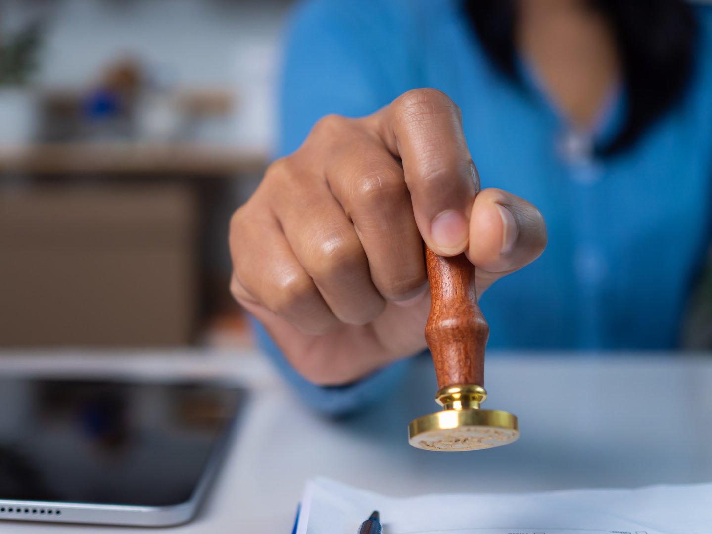 Approval stamp, Signing on business partner paper to success, Businesswoman hand stamping with approved stamp on text approved document at desk, Validates and manages business documents and agreements.