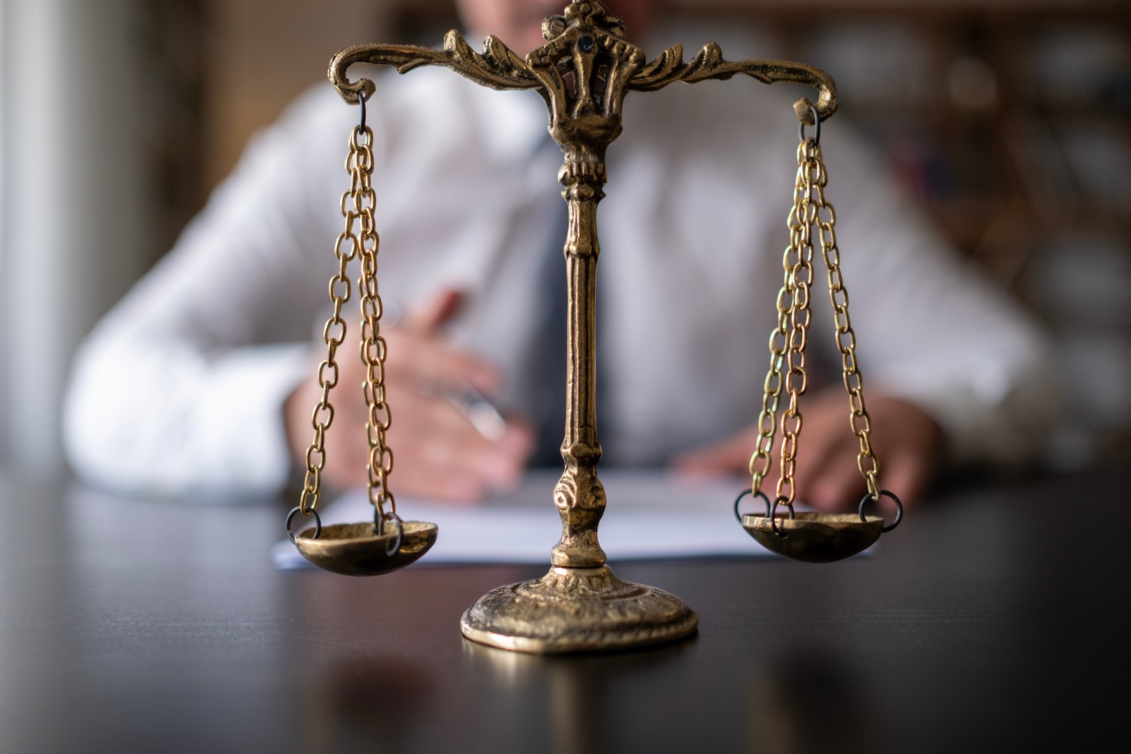 Golden scales in the hand of a man in a business suit