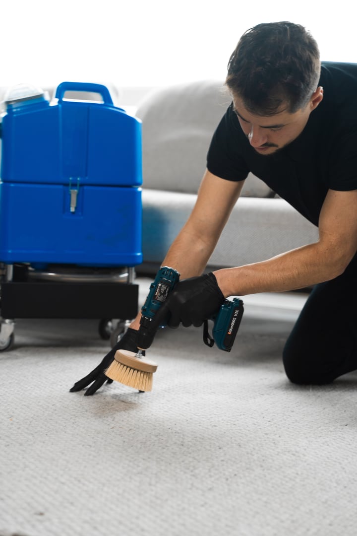 Cleaning the carpet at home using drill and brush. Easy removal of stains on carpet with drill and brush. Smearing detergent deep into fibers to clean carpet with drill and brush