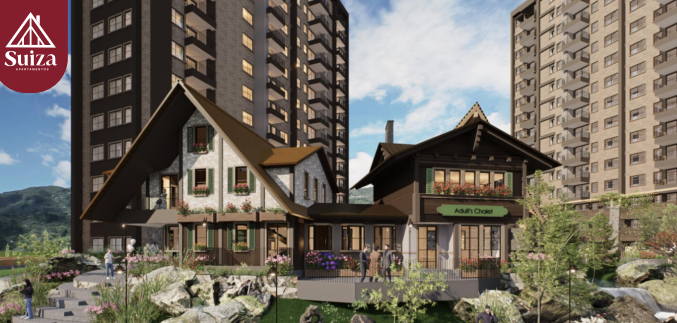 Modern apartment complex with chalet-style architecture, surrounded by gardens and mountains under a blue sky.