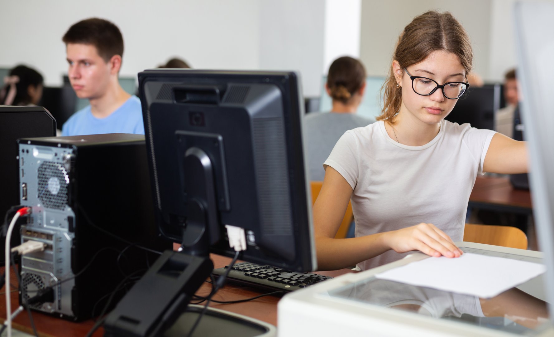 Focused girl using scanner in computer room in school