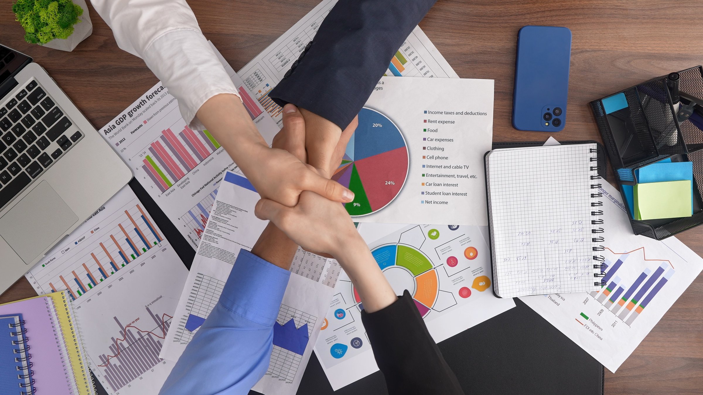 Business professionals collaborating on data analysis and strategic planning. Charts and documents on the desk illustrate teamwork and focus. Top shot