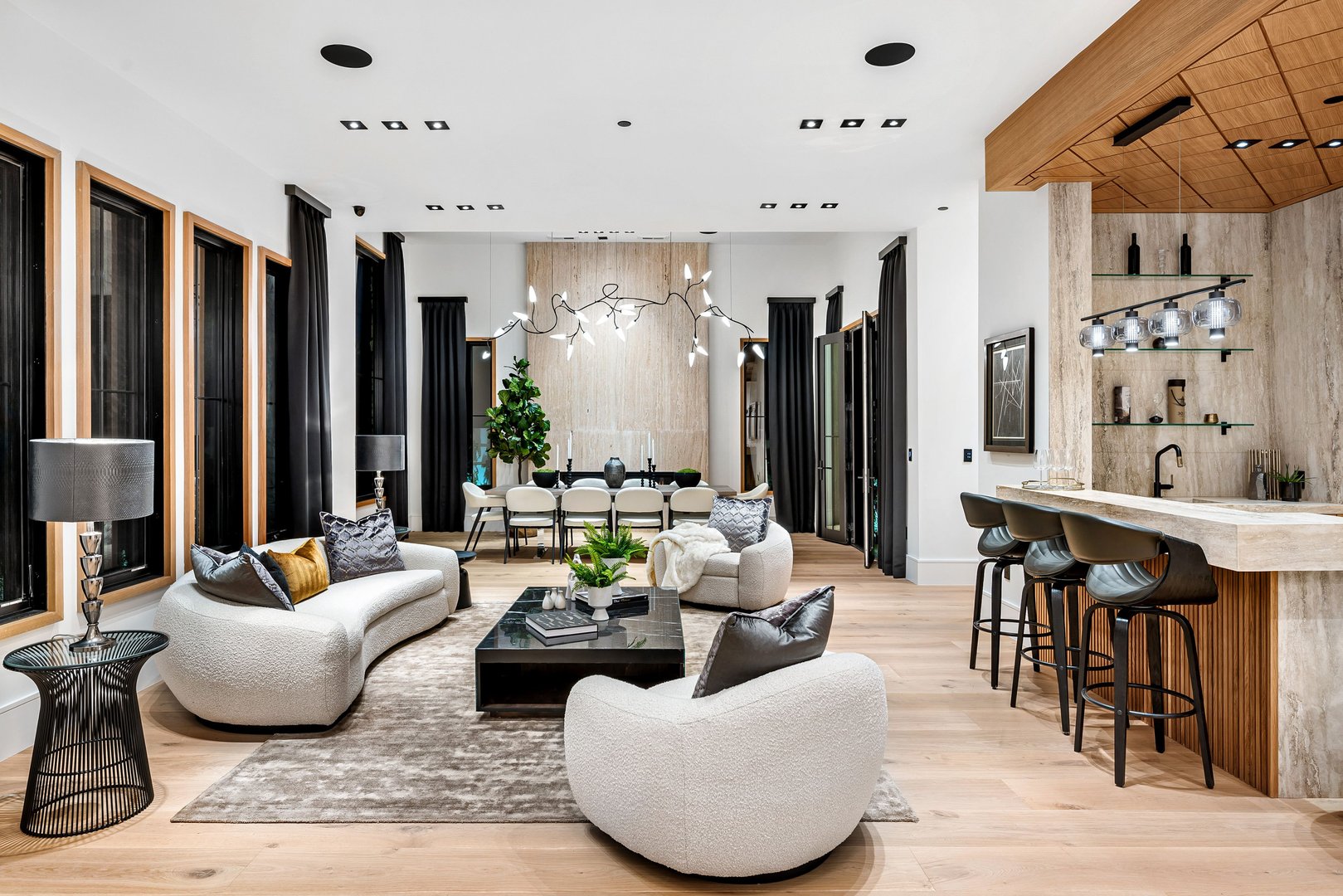 Modern luxury living room with contemporary furniture, bar area, and stylish decor, featuring neutral tones and natural light.