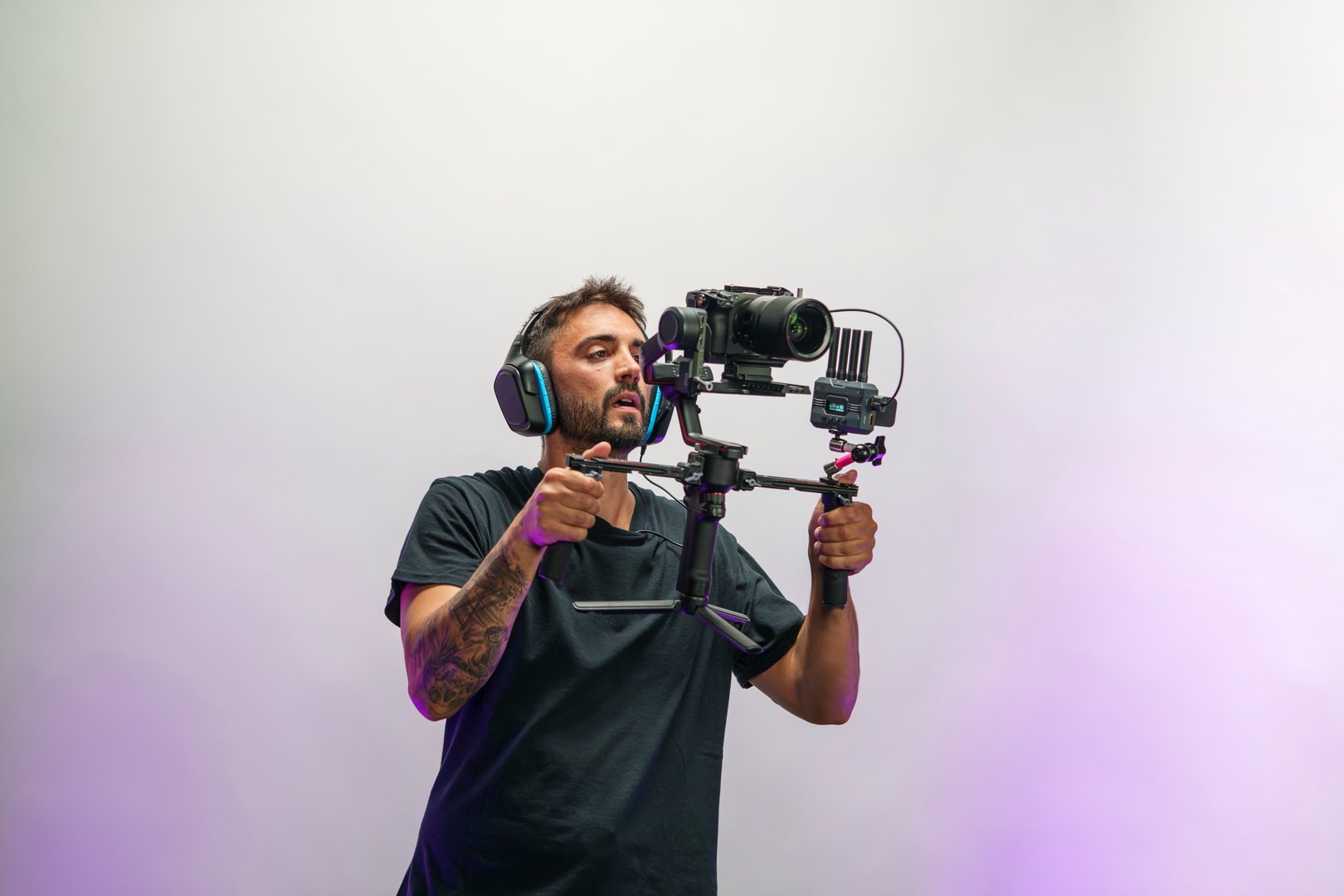 Young Male Camera Operator Using a Gimbal for Filming on a Professional TV Set with Headphones