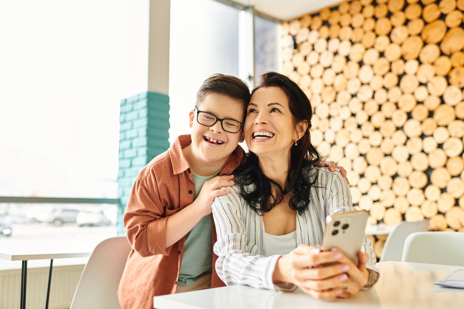 Mother and son share smiles and fun moments at a cozy cafe.