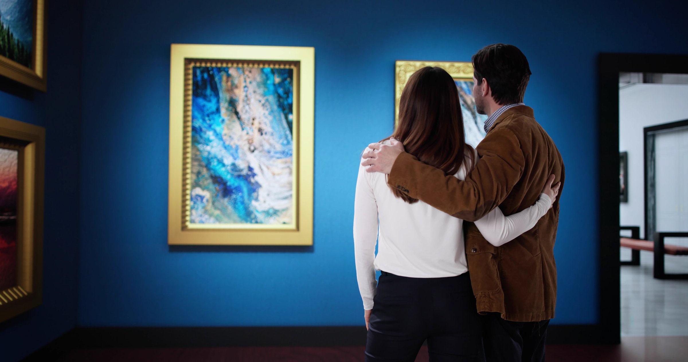 couple looking at contemporary abstract wall paintings in an exhibition