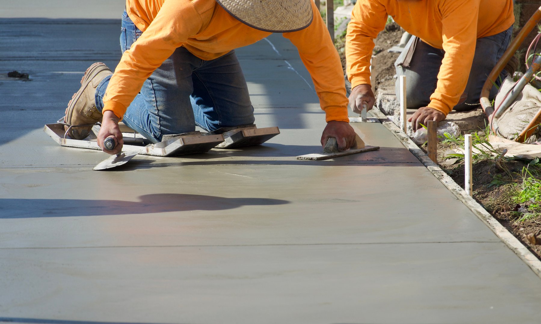 Construction workers putting finishing touch on concrete