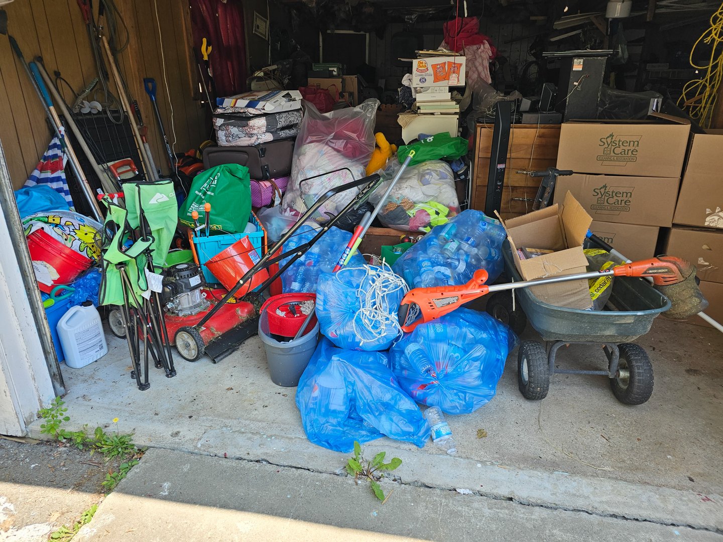 Liverpool NS, CAN, 8.19.2023 - A view of an open garage door with lots of clutter everywhere.